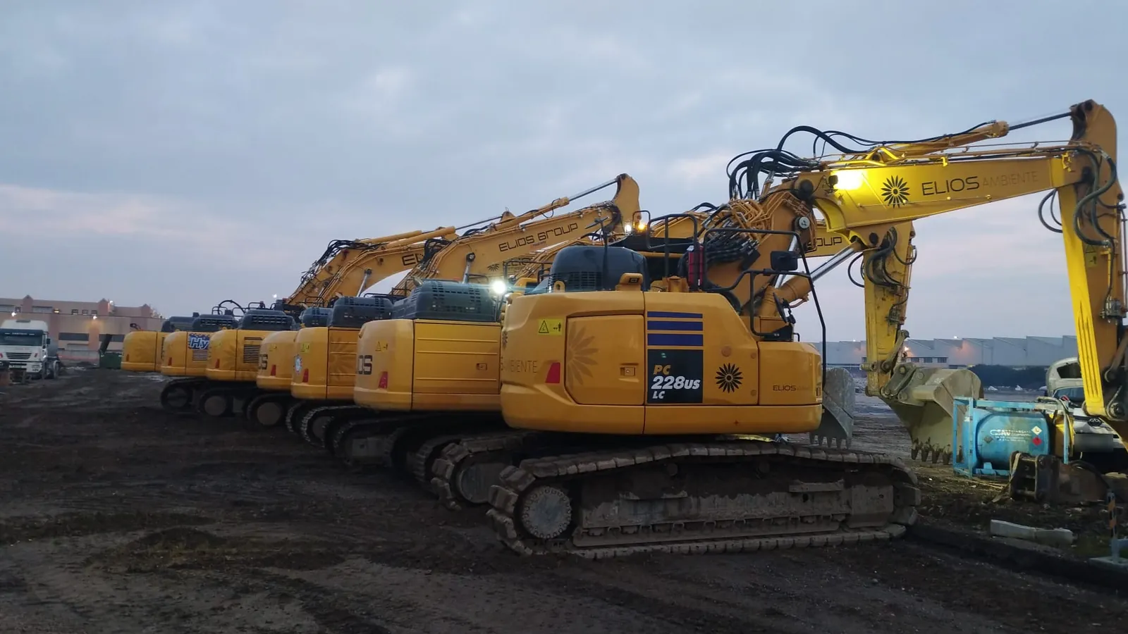 Fila di escavatori ELIOS Ambiente al crepuscolo in un’area di cantiere